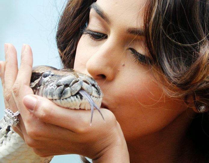 Девушка целует змею