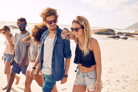Diverse group of young friends having a walk on the beach - Signs A Scorpio Man Likes You