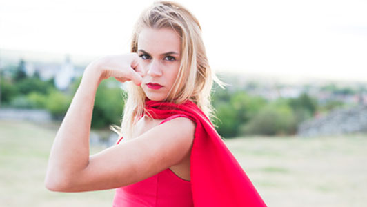 blonde woman in red flexing arm muscles